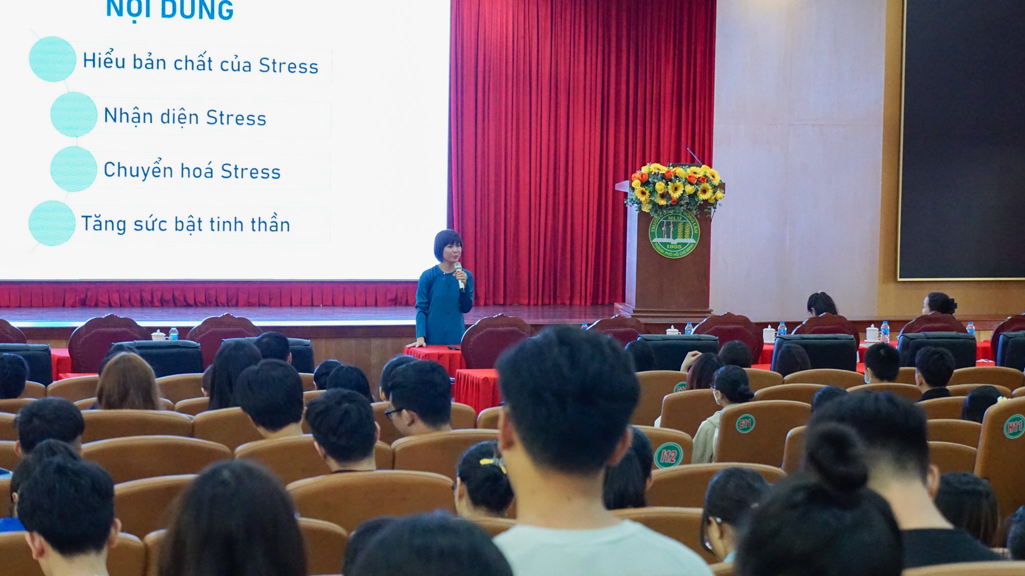 A person giving a presentation in front of a group of peopleDescription automatically generated